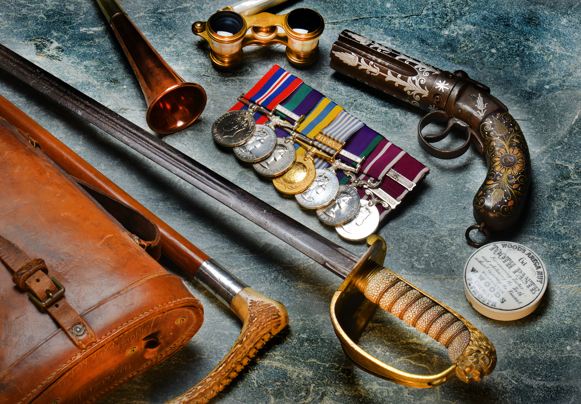 A collection of military antiques, medals, swords and a gun